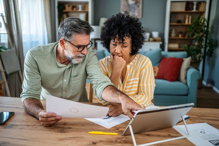 A middle aged couple reviewing their Abbot Labratories QDRO, 401k, pension, and retirement income advice from The Retirement Group.