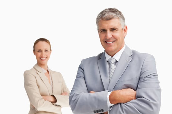 Smiling business people with folded arms against white background