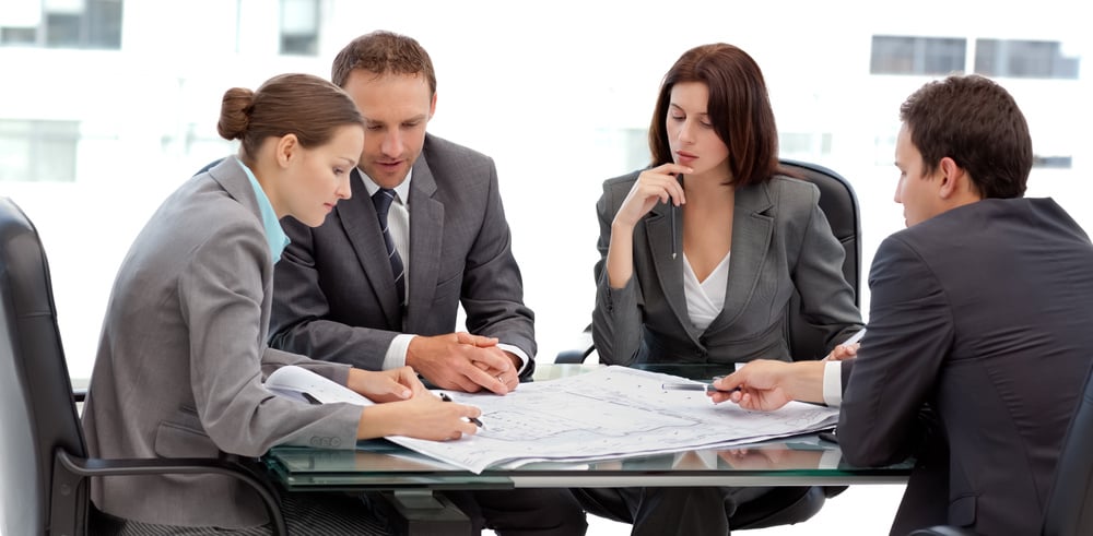 Four serious engineers looking at plans sitting at a table at work-Nov-05-2024-01-14-45-7729-AM